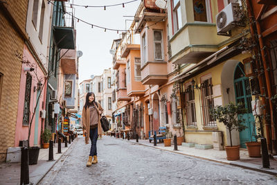 Rear view of woman walking on street in city