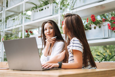 Young woman using laptop at cafe