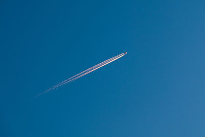 Low angle view of vapor trail in blue sky