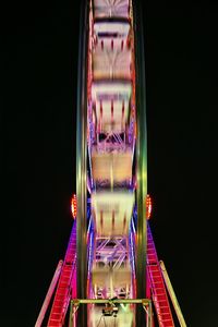 Blurred motion of illuminated ferris wheel against sky at night