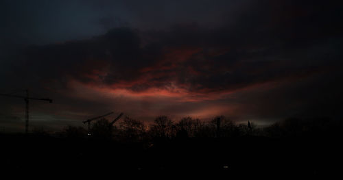 Silhouette of trees against cloudy sky