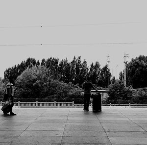 Rear view of man and woman standing against clear sky