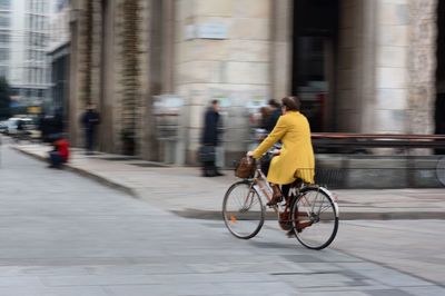 Women riding bicycle on city street