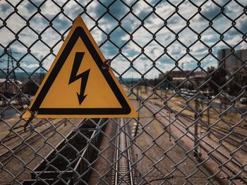 Close-up of warning sign on chainlink fence