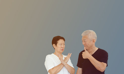 Young man standing against black background