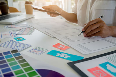 Midsection of woman working on paper at table