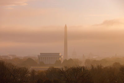 Scenic view of city against sky during sunset