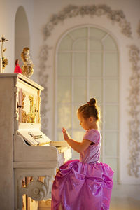 Beautiful girl playing piano in beautiful dress