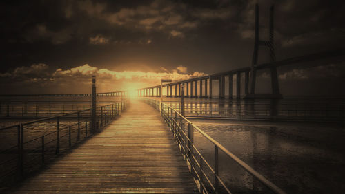 Bridge over sea against sky during sunset