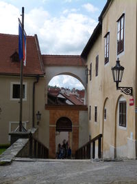 People on street amidst buildings against sky