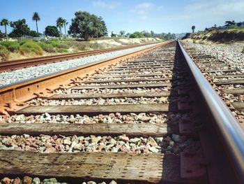 Railroad tracks by trees against sky