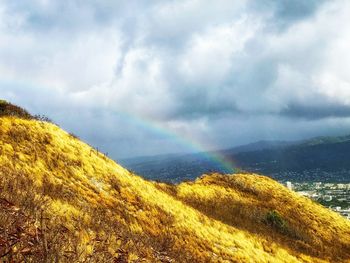 Scenic view of rainbow over mountain against sky