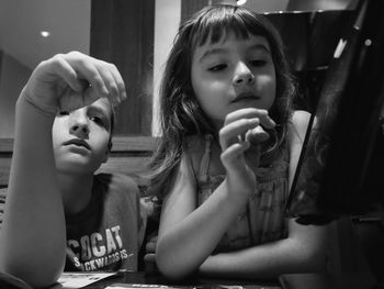 Close-up of siblings using digital tablet at table