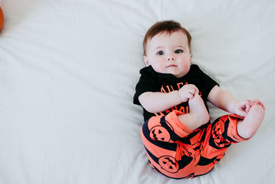 High angle portrait of cute baby lying on bed