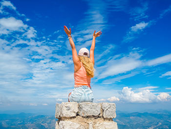 Young girl sitting on a stone with a beautiful view from the top of mont ventoux