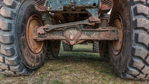 Close-up of old rusty wheel on field