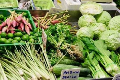 High angle view of vegetables and flower buds with labels at market stall