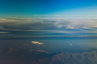 Scenic view of sea and mountains against blue sky