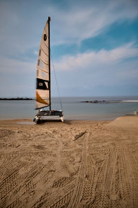 Sailboat on beach against sky