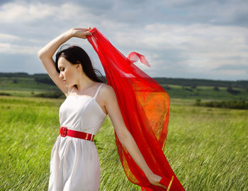 Side view of young woman standing on field