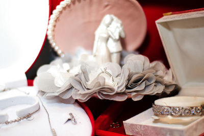 Close-up of wedding figurines and jewelry on table