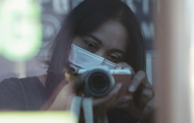 Portrait of woman wearing mask photographing outdoors