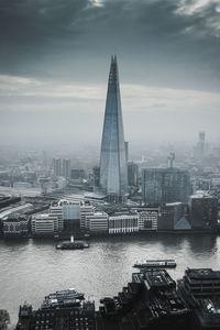 Aerial view of buildings against cloudy sky