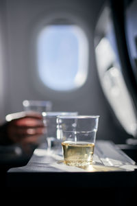 Disposable cups of drinks on table against airplane window. refreshment during flight.