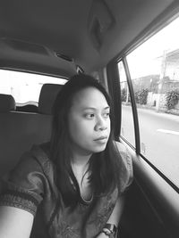 Portrait of young woman sitting in car