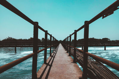 Bridge over sea against clear sky