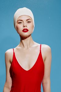 Portrait of young woman standing against blue sky