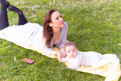 Portrait of woman lying on grassy field