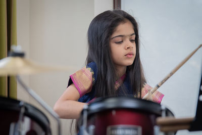 Girl in sari playing drum