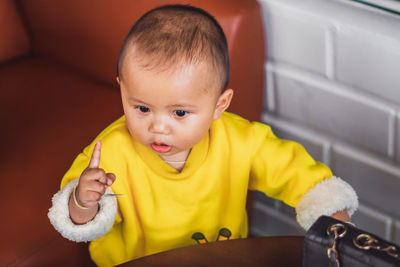 Portrait of cute baby boy sitting on slide at home