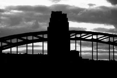 Low angle view of silhouette bridge against sky in city