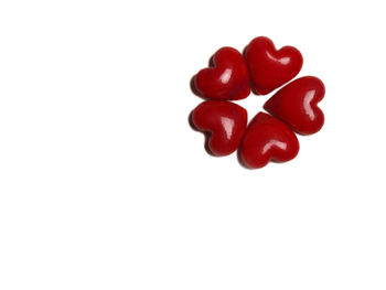 Close-up of red heart shape over white background