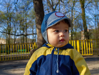 Young cute boy looking left side distance during an early spring day in the park.