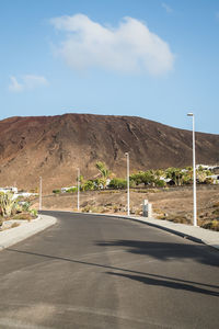 Road by mountain against sky