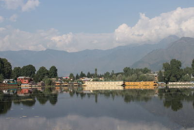 Scenic view of lake by mountains against sky