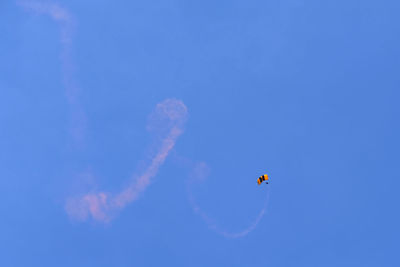 Low angle view of airshow flying against clear sky