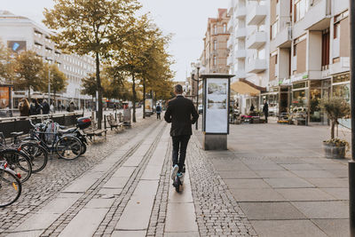 Rear view of man using scooter