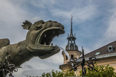 Low angle view of statue against building against sky