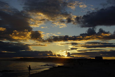 Scenic view of sea against cloudy sky during sunset