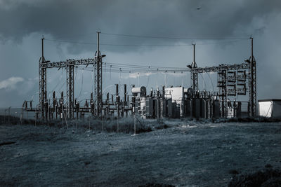 Electricity pylon on field against sky
