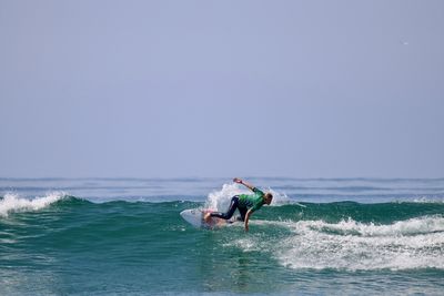 Man surfing in sea against clear sky