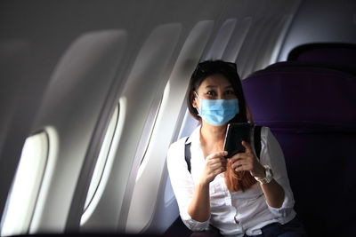 Portrait of young woman sitting in airplane