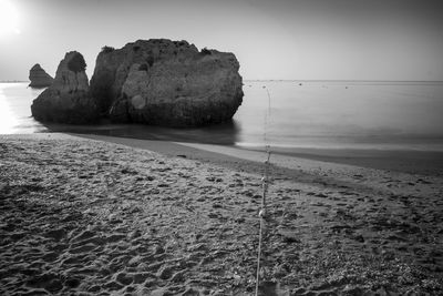 Rocks on beach against clear sky
