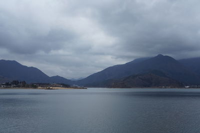 Scenic view of sea and mountains against sky