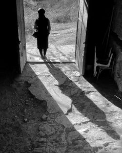 Rear view of woman standing at doorway