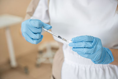 Midsection of doctor holding syringe